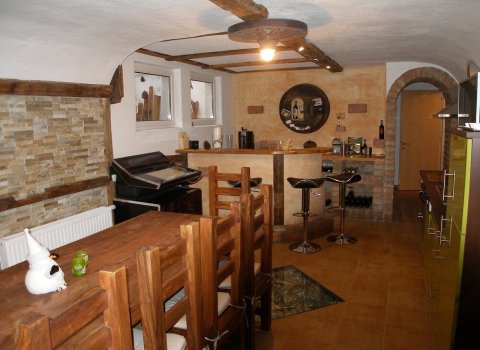 Gemütliche Küche mit Bar, Holzstuhl und modernen Elementen in den Appartements Wälderhof.